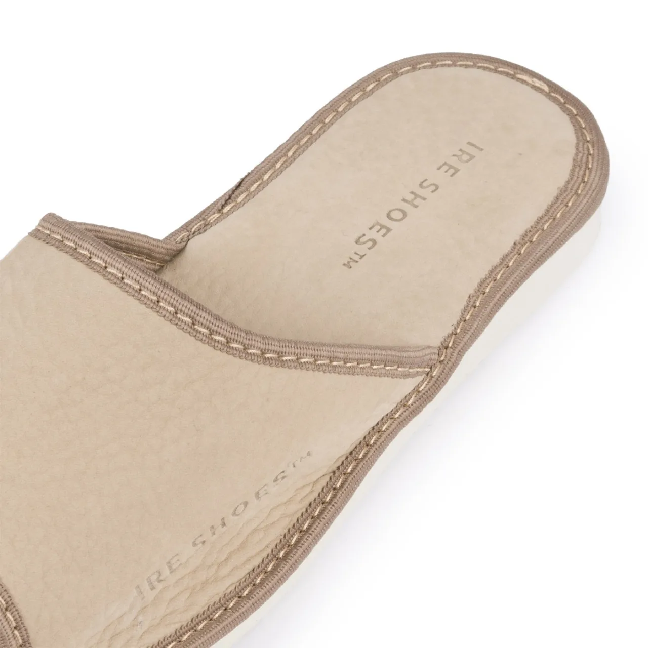 Zbliżenie beżowego wierzchu i wkładki kapci KODLG25-240 z wytłoczonym logo IRE SHOES