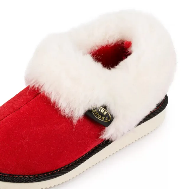 Zbliżenie jasnego kołnierza i czarnej metki IRE SHOES na czerwonym bamboszu