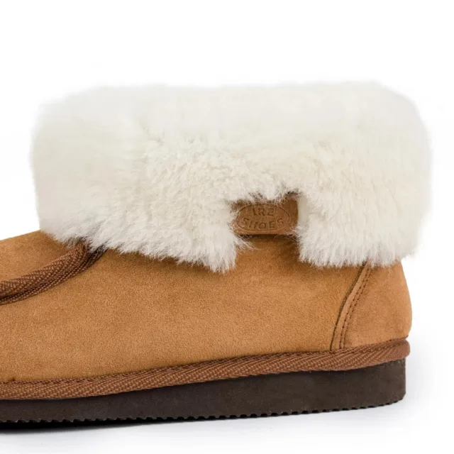 Zbliżenie jasnego kołnierza, metki IRE SHOES i szwu przy pięcie
